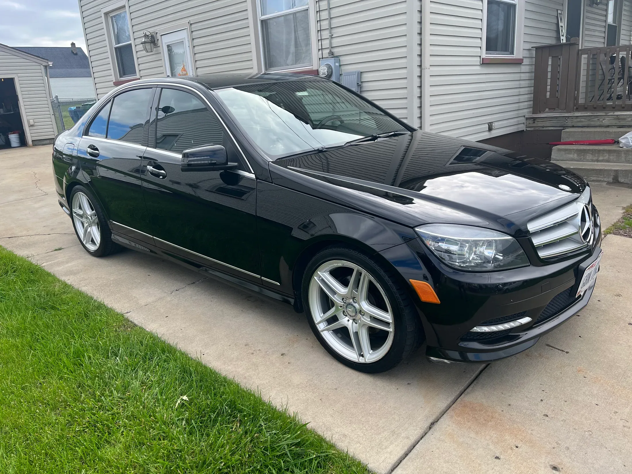 Detailed black Mercedes-Benz sedan parked in a driveway.