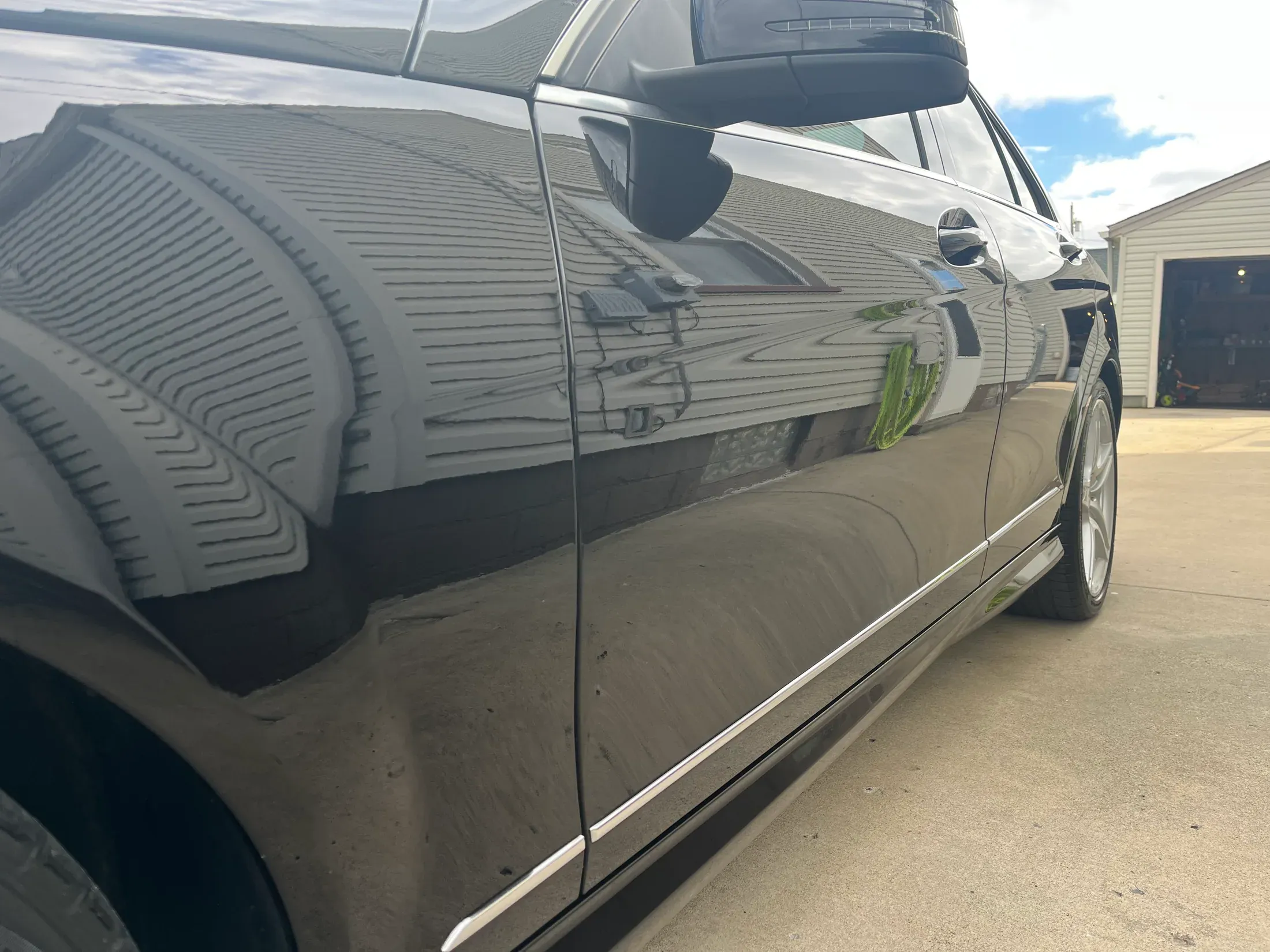 Close view of reflections in the polished black Mercedes-Benz paint.