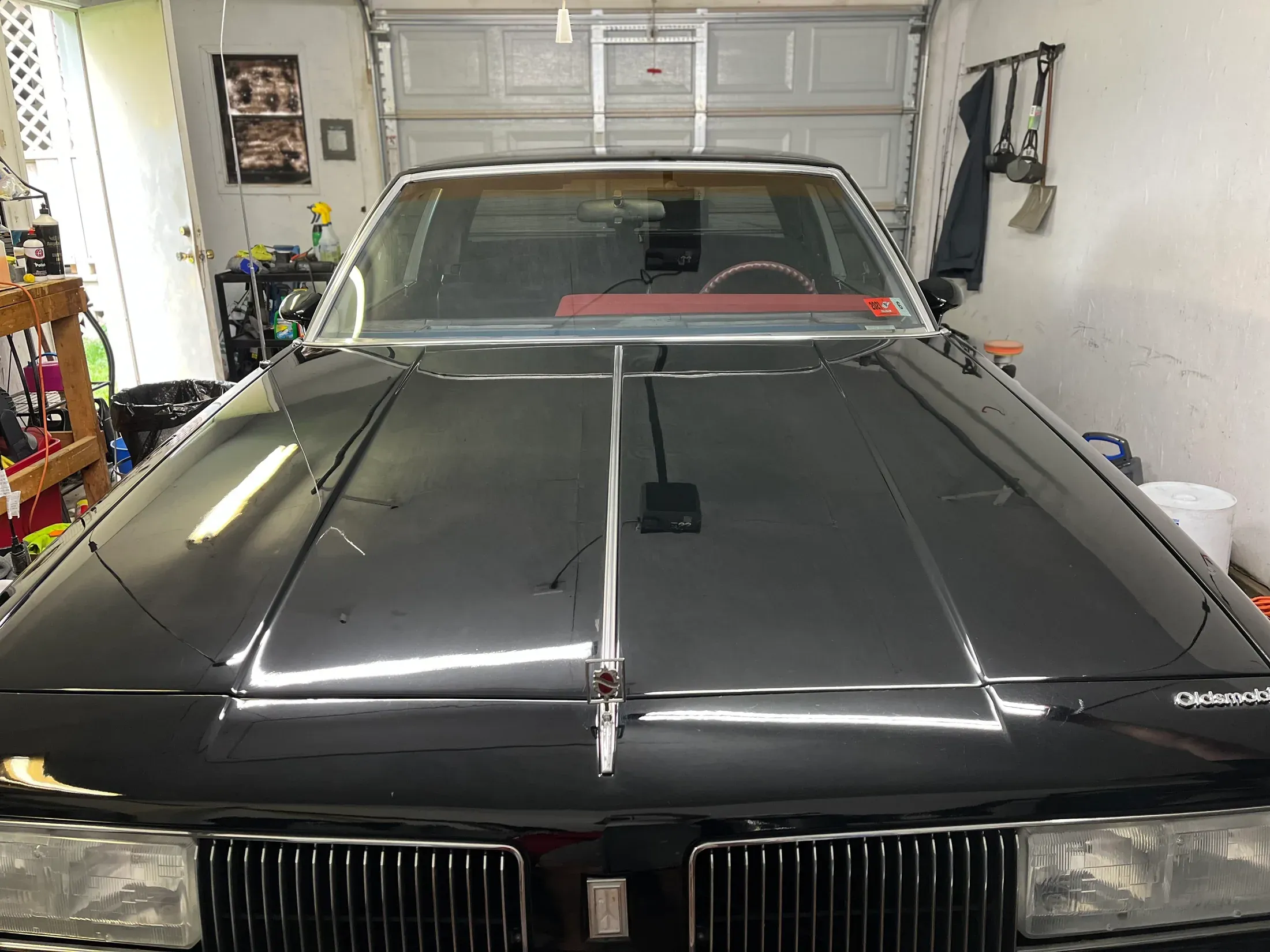Classic black car after detailing, viewed from the front.