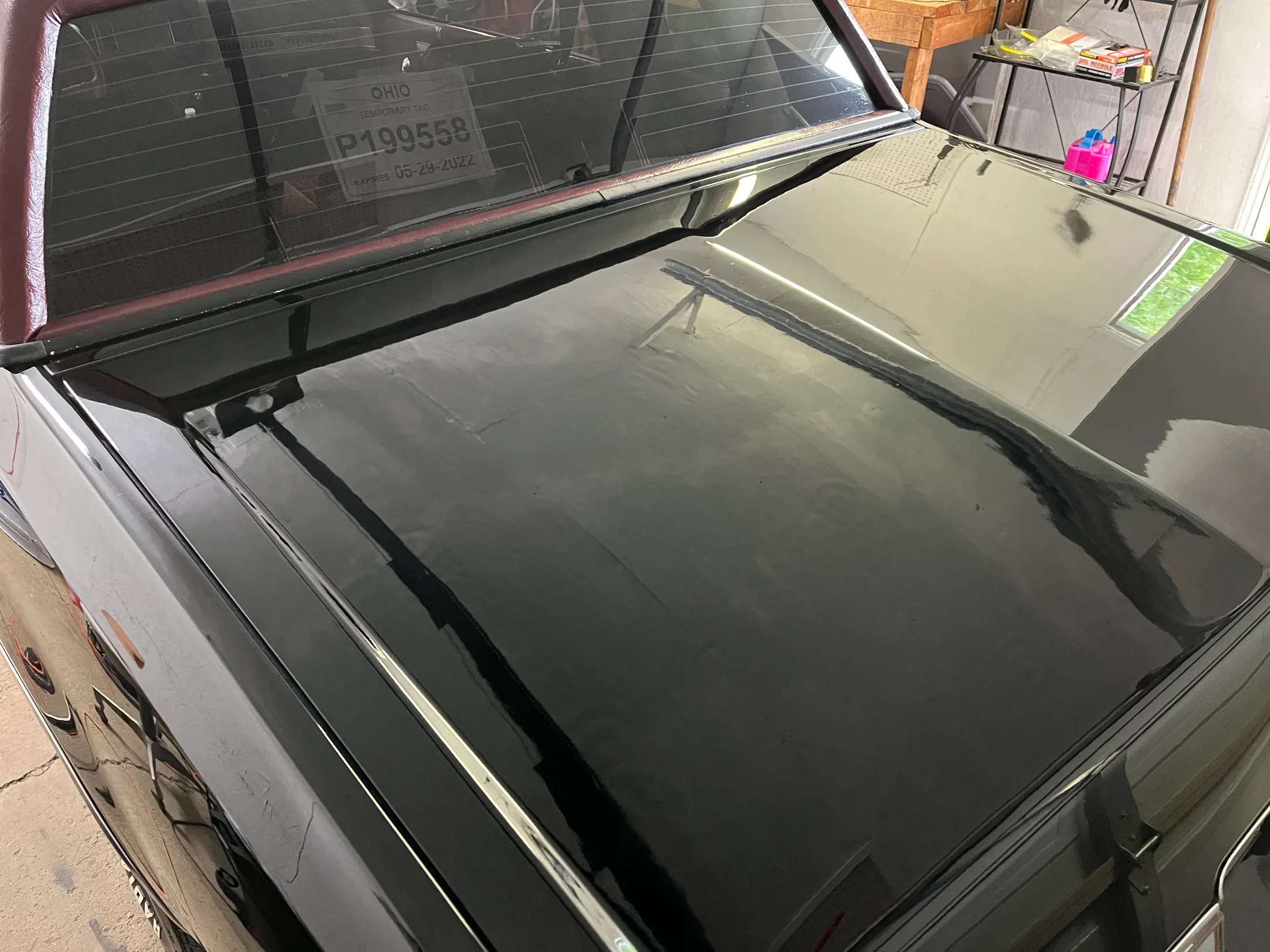 Glossy black finish reflected along the side of a classic car.